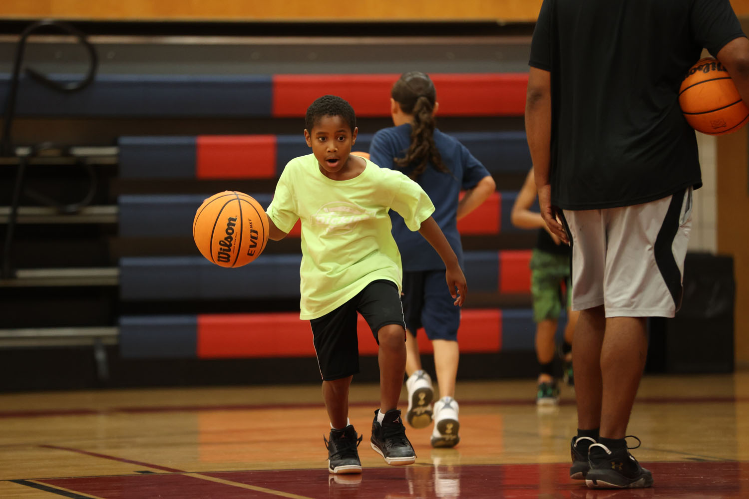 Young camper dribbling down the court